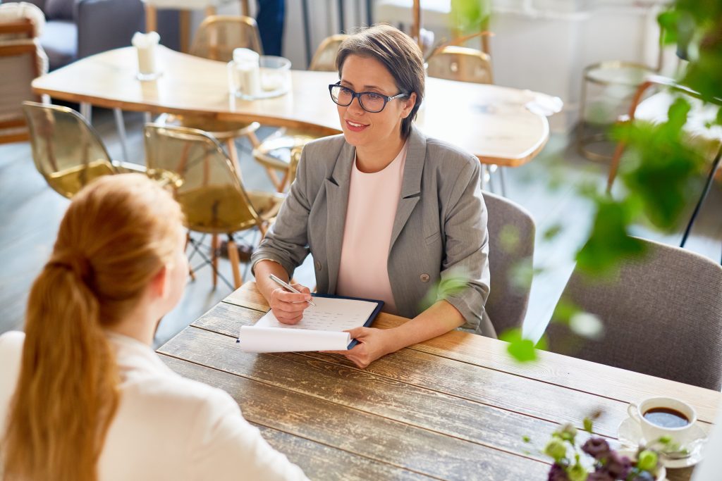 Confident owner interviewing young call center specialist